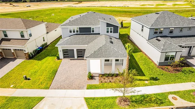 a front view of a building with garden and trees