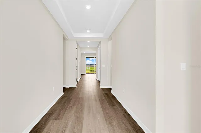 a view of a hallway with wooden floor