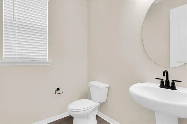 a bathroom with a sink a toilet and a mirror