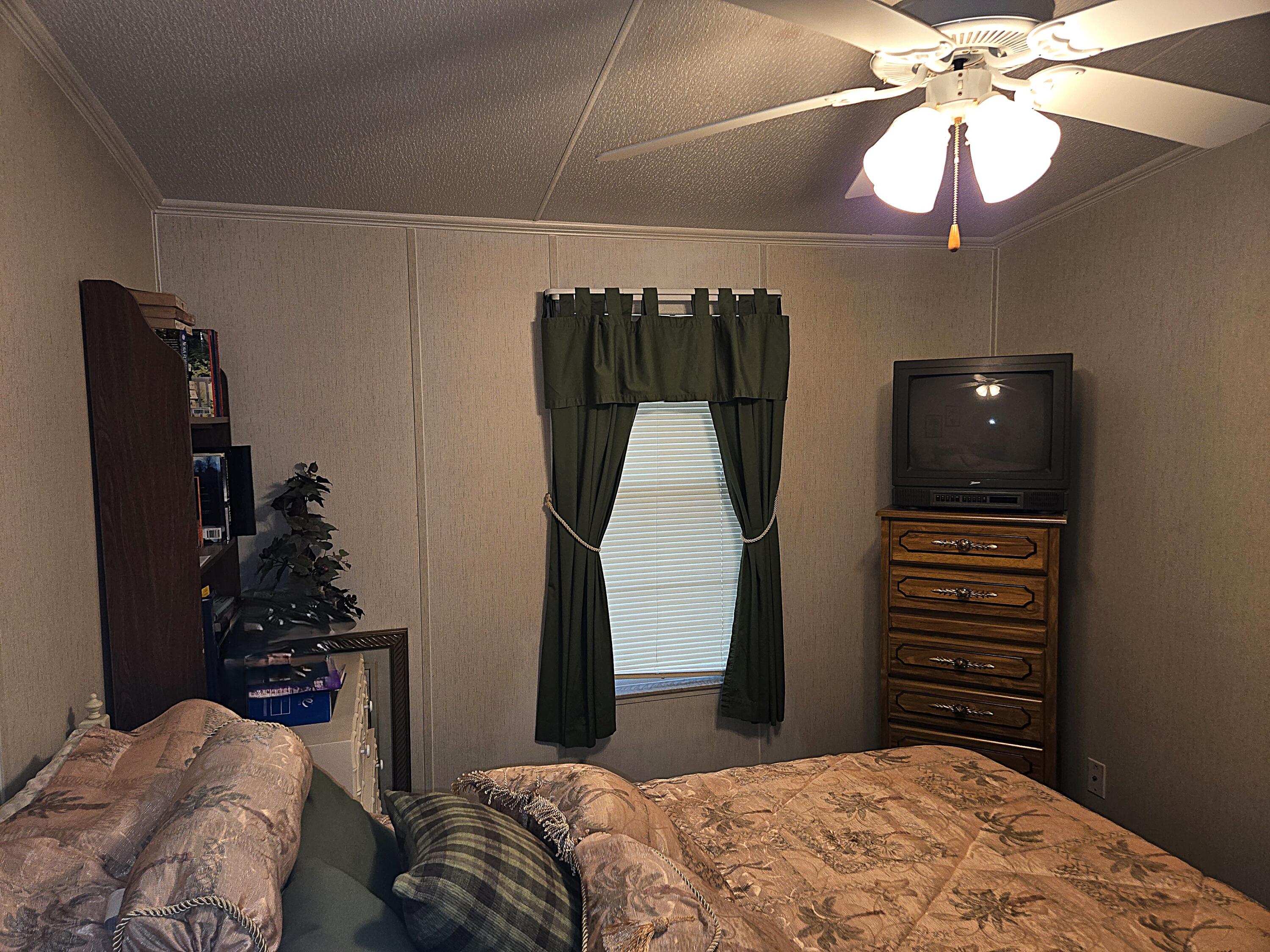 2425 Southeast 31st Street Okeechobee, FL 34974 - Photo 24 of 43 a bedroom with a bed and a chandelier