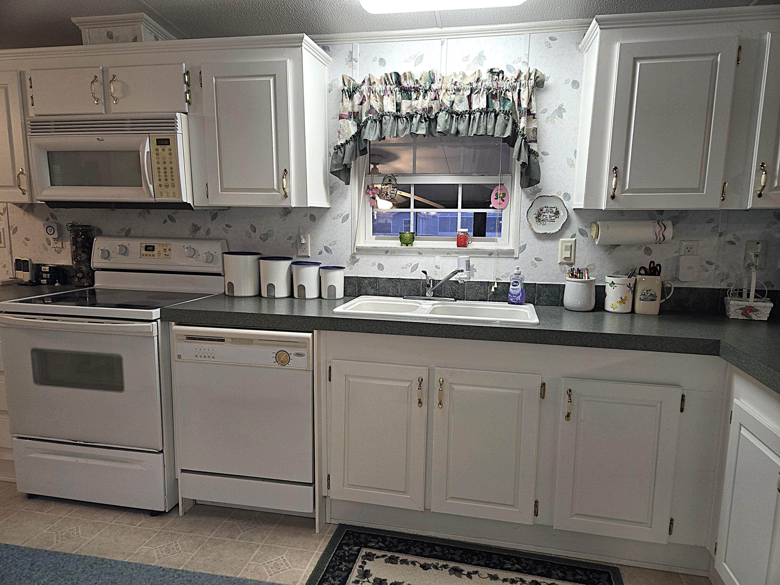 2425 Southeast 31st Street Okeechobee, FL 34974 - Photo 9 of 43 a kitchen with stainless steel appliances granite countertop white cabinets and a sink