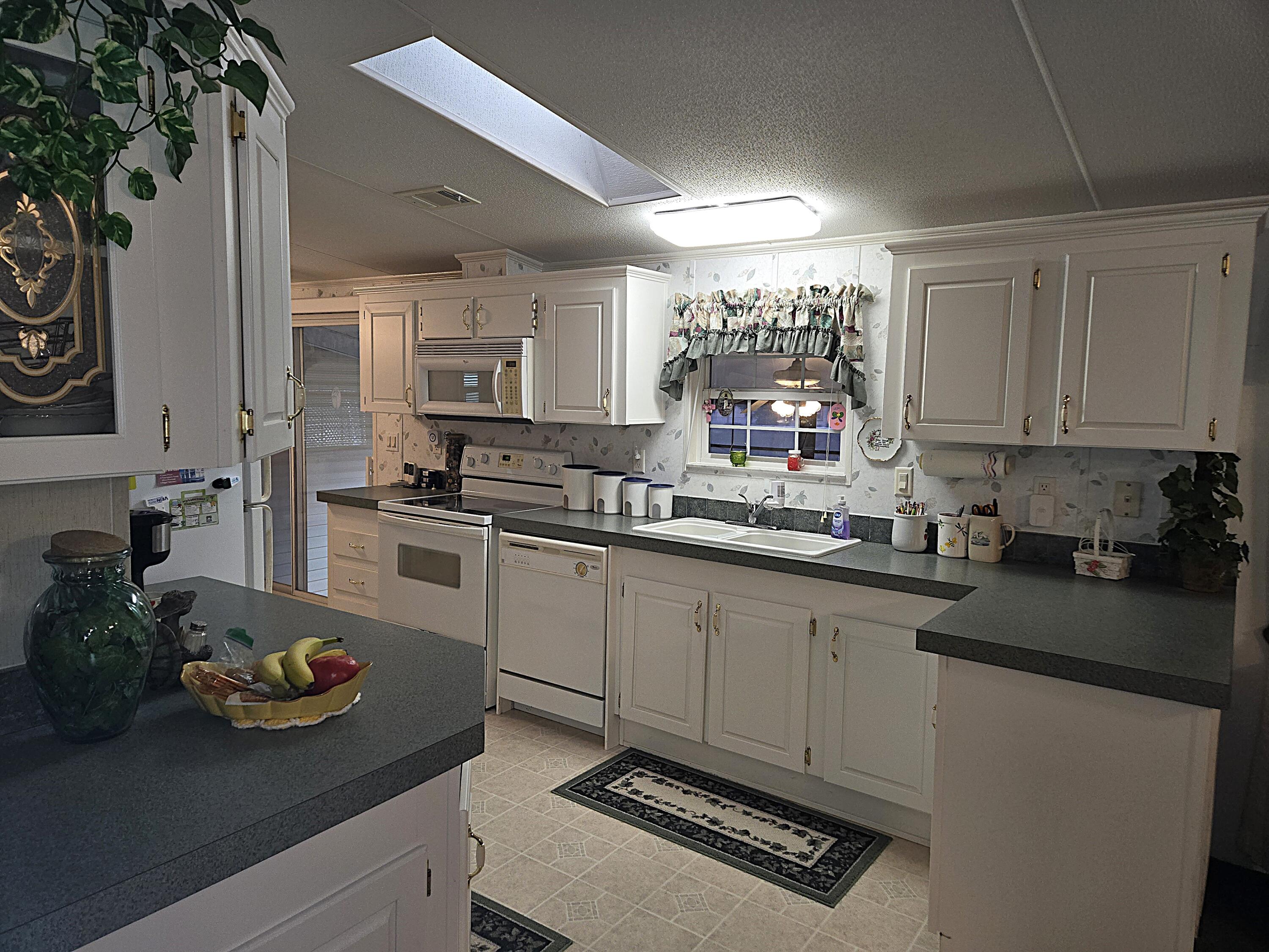 2425 Southeast 31st Street Okeechobee, FL 34974 - Photo 10 of 43 a kitchen with sink a stove and cabinets