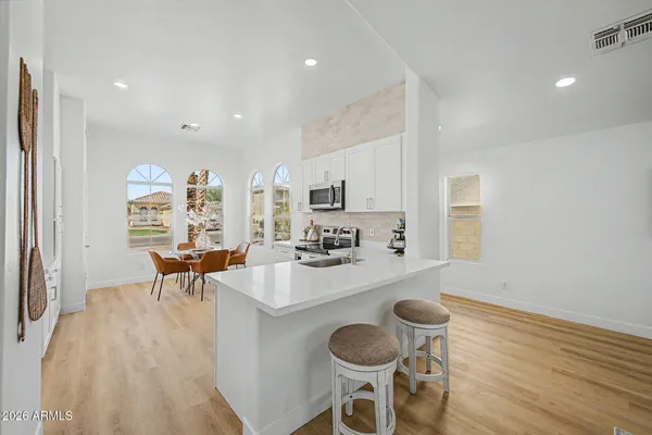a kitchen with a dining table chairs and a refrigerator