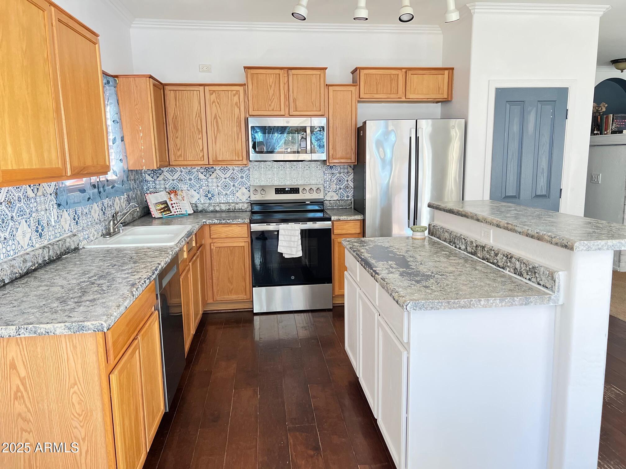 45353 West Sandhill Road Maricopa, AZ 85139 - Photo 11 of 20 a kitchen with stainless steel appliances granite countertop a stove a sink dishwasher and a refrigerator