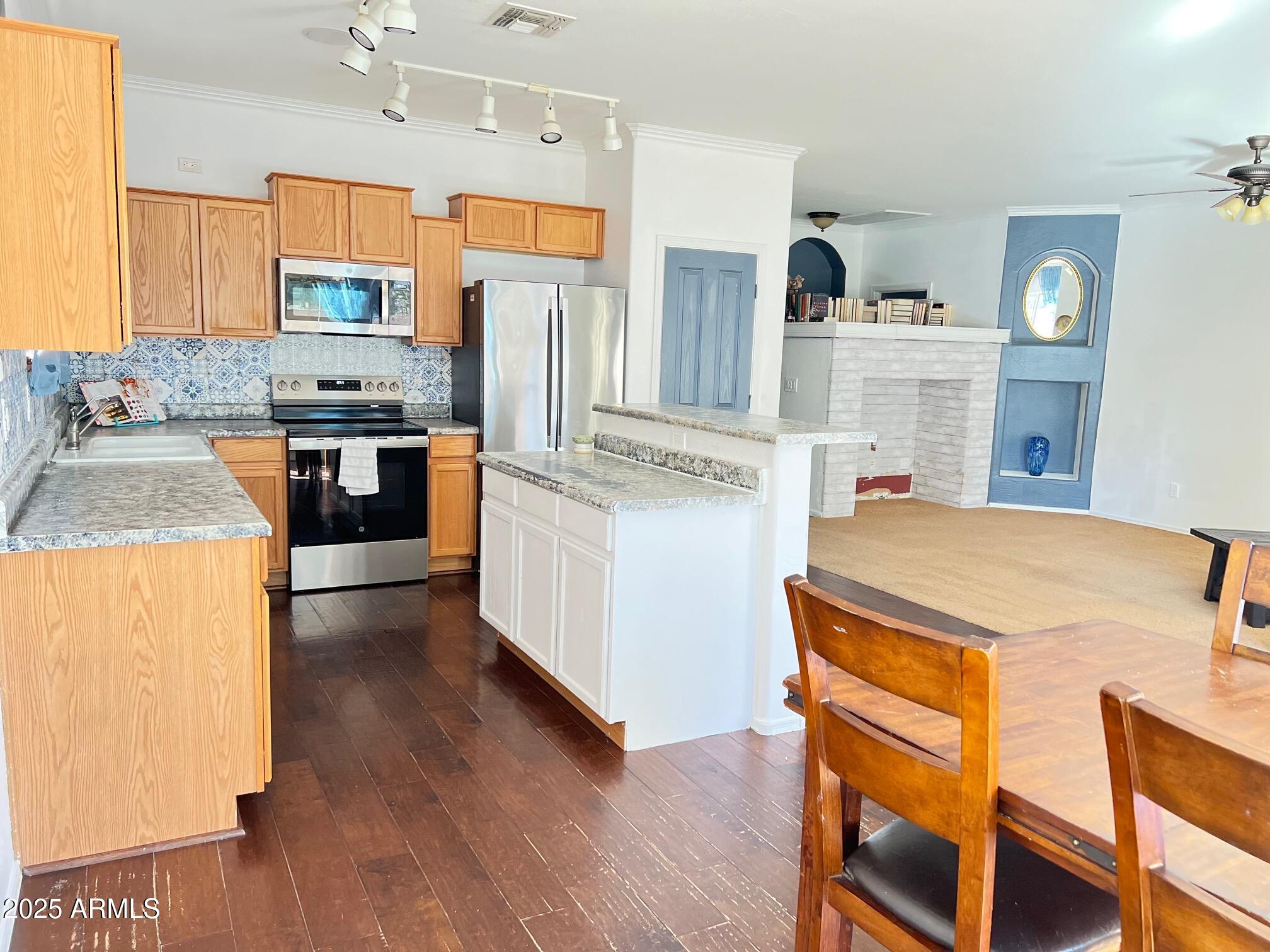 45353 West Sandhill Road Maricopa, AZ 85139 - Photo 9 of 20 a kitchen with stainless steel appliances granite countertop a refrigerator a stove and a sink