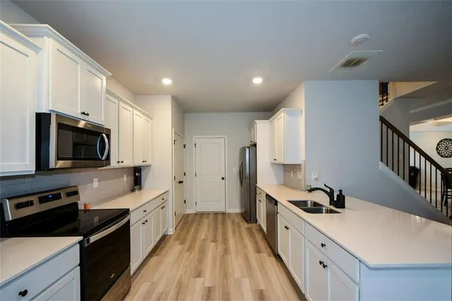 a large white kitchen with a refrigerator a sink and a stove
