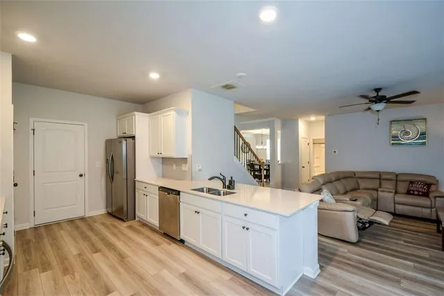 a kitchen with white cabinets stainless steel appliances and a sink