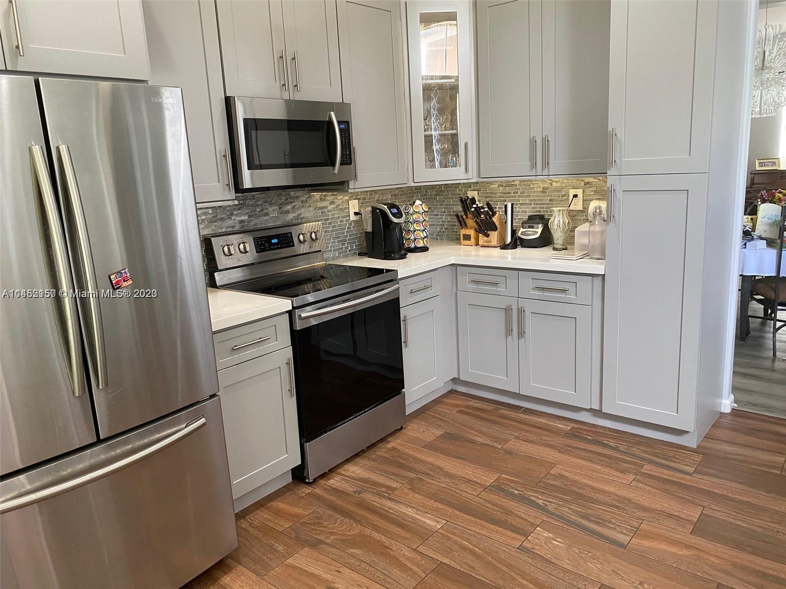 a kitchen with stainless steel appliances granite countertop a refrigerator stove and sink