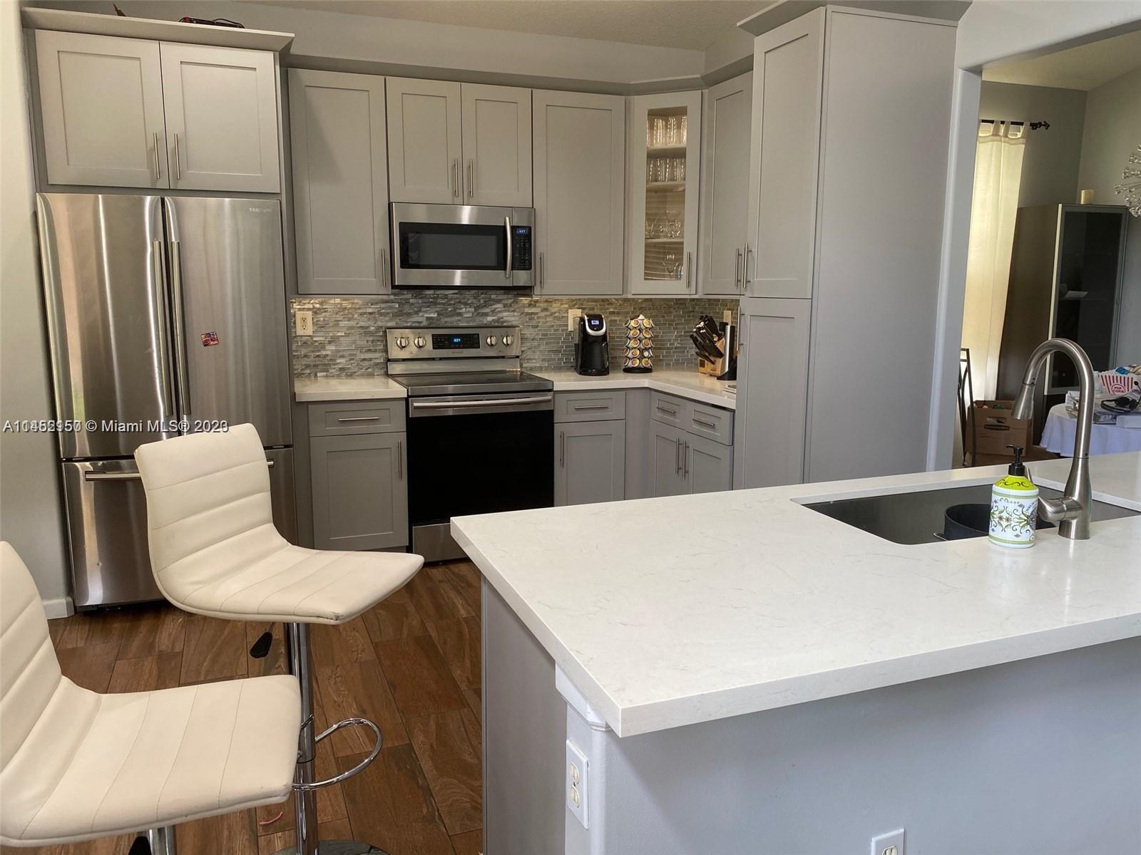 Miramar Miramar, FL 33029 - Photo 2 of 8 a kitchen with stainless steel appliances a stove a sink a microwave a refrigerator and white cabinets