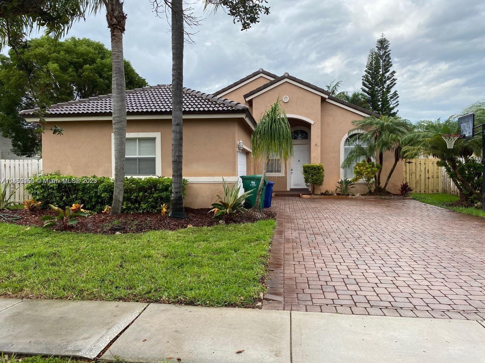 Miramar Miramar, FL 33029 - Photo 7 of 8 a front view of a house with a yard and potted plants