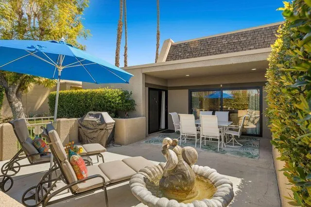 a patio with a table and chairs under an umbrella
