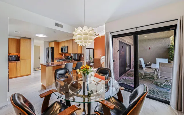 a view of a dining room with furniture a chandelier and wooden floor