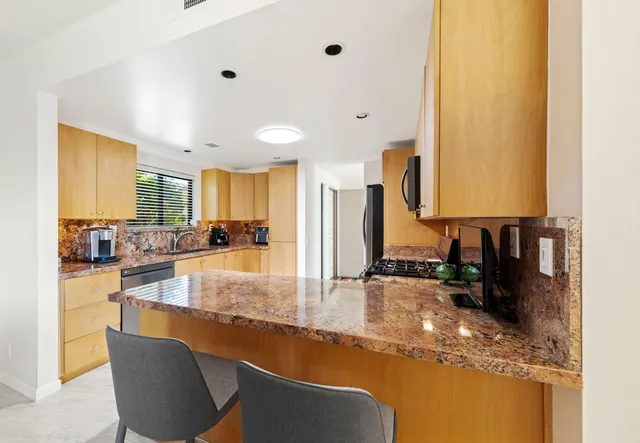 a kitchen with granite countertop sink and cabinets