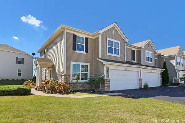 a front view of a house with a yard and garage