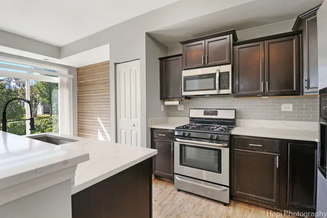 a kitchen with granite countertop a stove microwave and sink