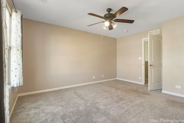an empty room with closet and a ceiling fan