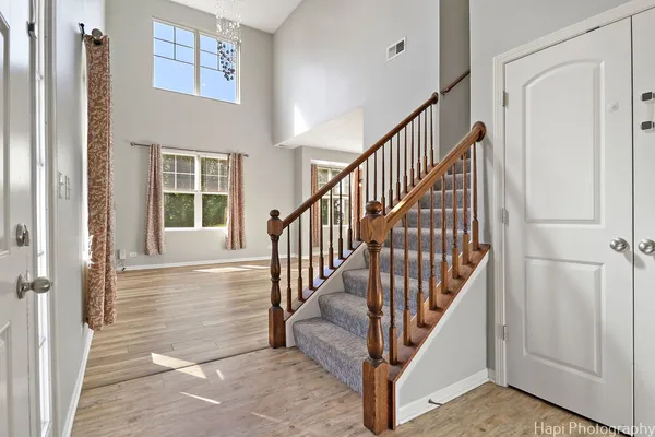 a view of staircase with lots of frames on wall and a window