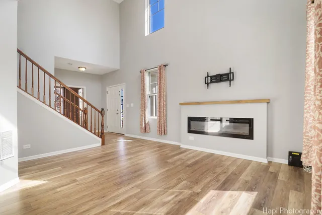 a view of a livingroom with wooden floor and staircase