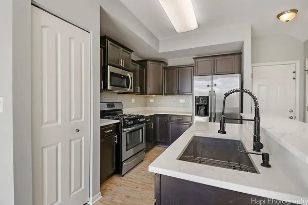 a kitchen with granite countertop a stove a sink and a microwave