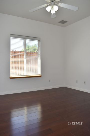919 Sims Street Ridgecrest, CA 93555 - Photo 10 of 32 an empty room with wooden floor and windows