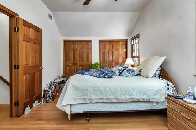 a bedroom with a bed and wooden floor