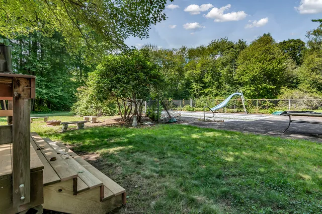 a view of yard with swimming pool and green space