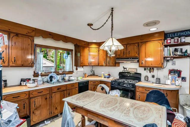 a kitchen with a sink appliances cabinets and a window