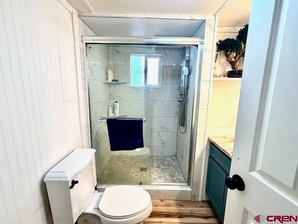 a bathroom with a granite countertop shower a sink and a mirror