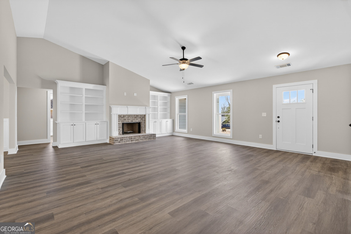 97 Wards Creek Road, Unit 1 Toccoa, GA 30577 - Photo 6 of 55 an empty room with wooden floor fireplace and windows