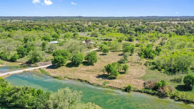 an aerial view of residential houses with outdoor space and trees all around