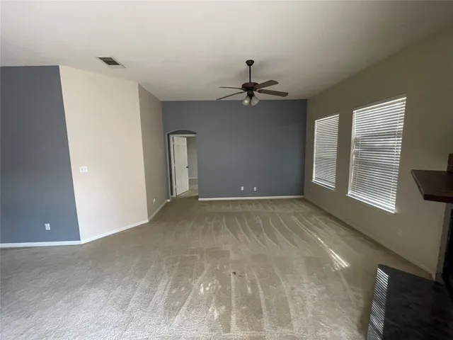 a view of a livingroom with a ceiling fan and window