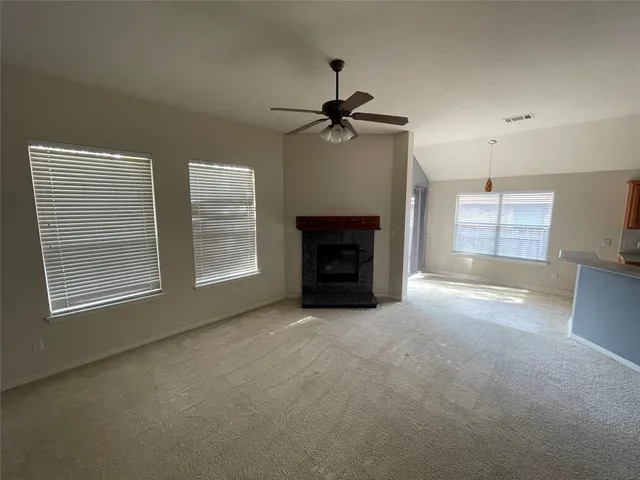 an empty room with windows and fireplace