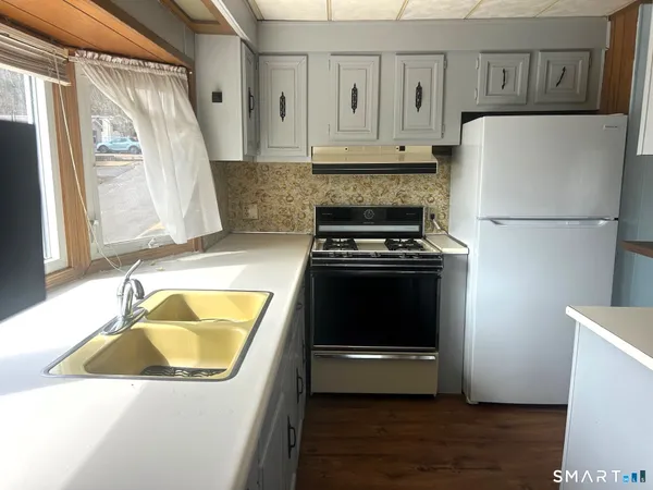 a kitchen with wooden cabinets and white appliances