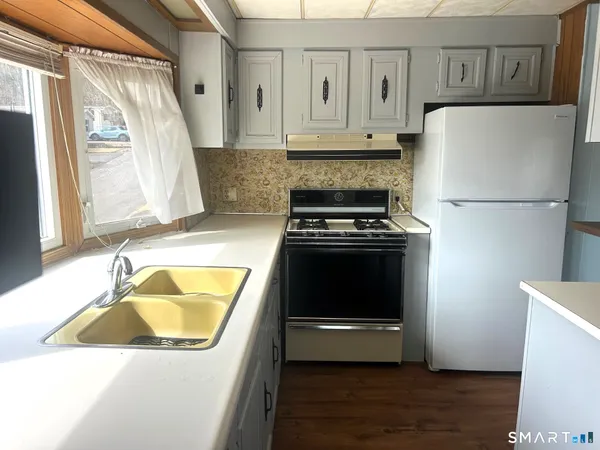 a kitchen with wooden cabinets and white appliances
