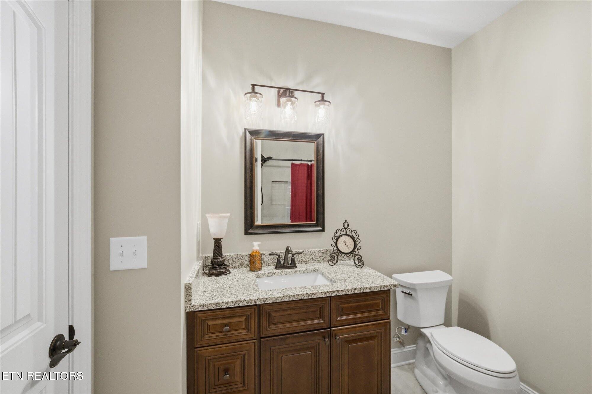7122 Volunteer Rdg Lane Knoxville, TN 37918 - Photo 25 of 34 a bathroom with a granite countertop sink vanity mirror and toilet