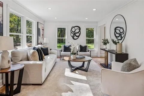 a kitchen with a sink dishwasher stove and white cabinets with wooden floor
