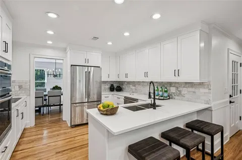 a dining room with furniture potted plants and wooden floor