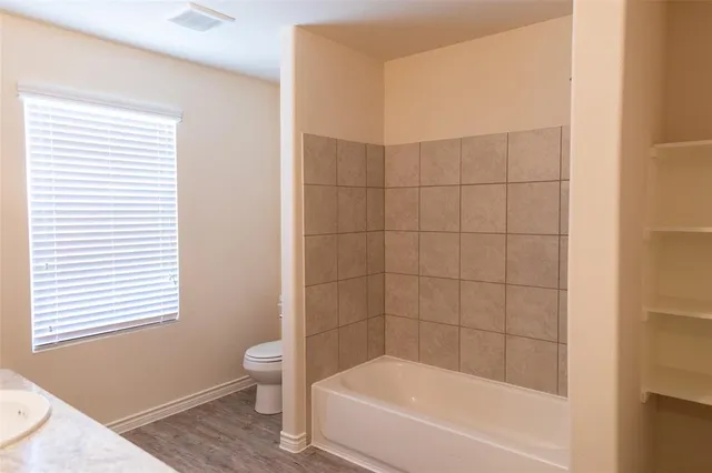 a bathroom with a bathtub and a window