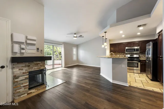 a kitchen with stainless steel appliances kitchen island granite countertop a stove top oven and sink