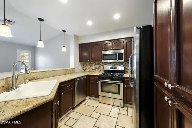 a kitchen with stainless steel appliances granite countertop a sink stove and refrigerator