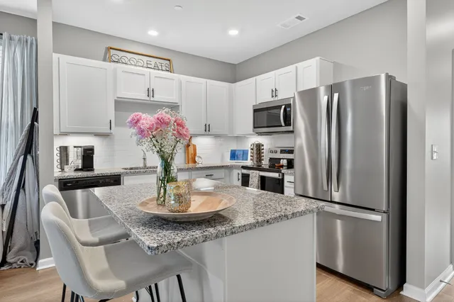a kitchen with stainless steel appliances granite countertop a refrigerator and a stove top oven