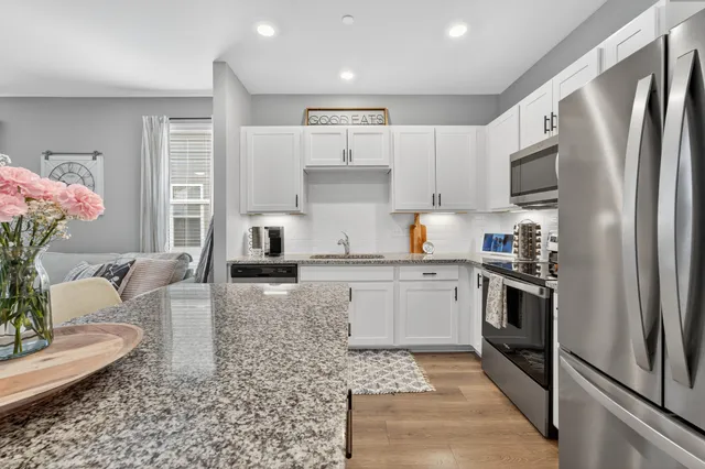 a kitchen with stainless steel appliances granite countertop a refrigerator sink and stove