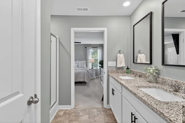 a en suite bathroom with a granite countertop sink and a mirror