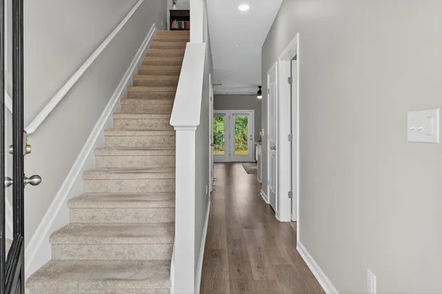 a view of a hallway with wooden floor and entryway
