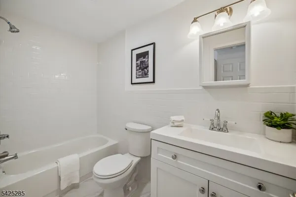 a bathroom with a sink a mirror a toilet and a bathtub