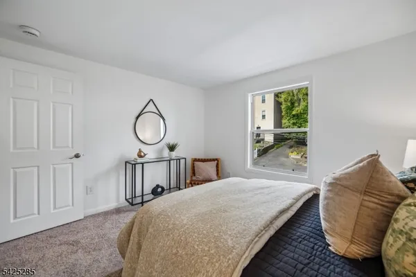 a bedroom with a bed a window and dresser