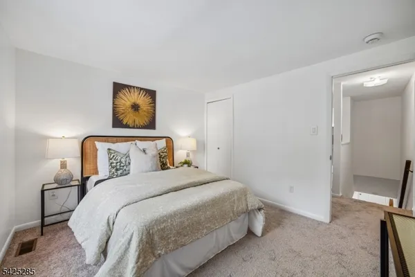 a bedroom with a bed and painting on the wall