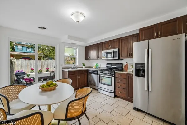 a kitchen with sink refrigerator dining table and chairs