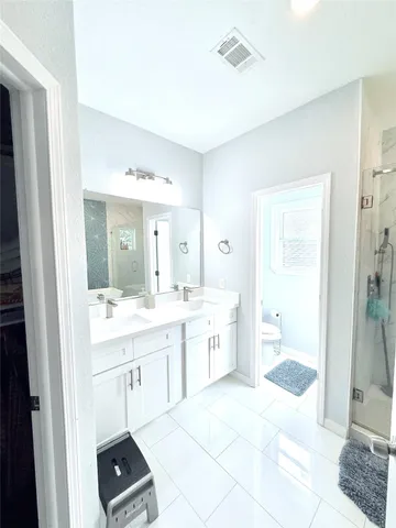 a spacious bathroom with a shower a sink and a mirror