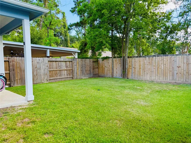 a view of a backyard with a fence and wooden fence